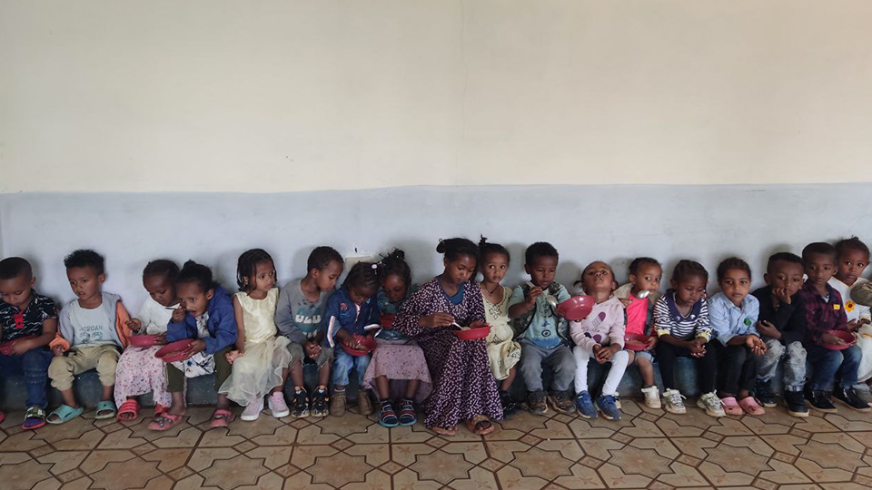 Gruppo di bambini durante il pranzo